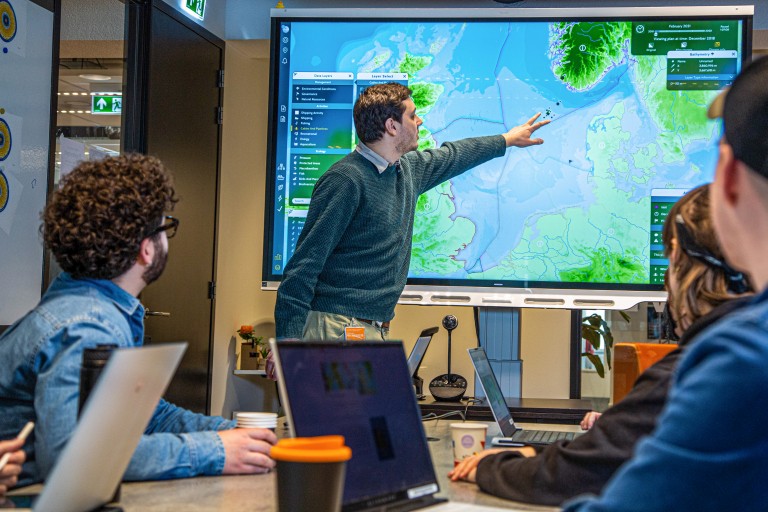 Een man geeft een presentatie voor een Digibord