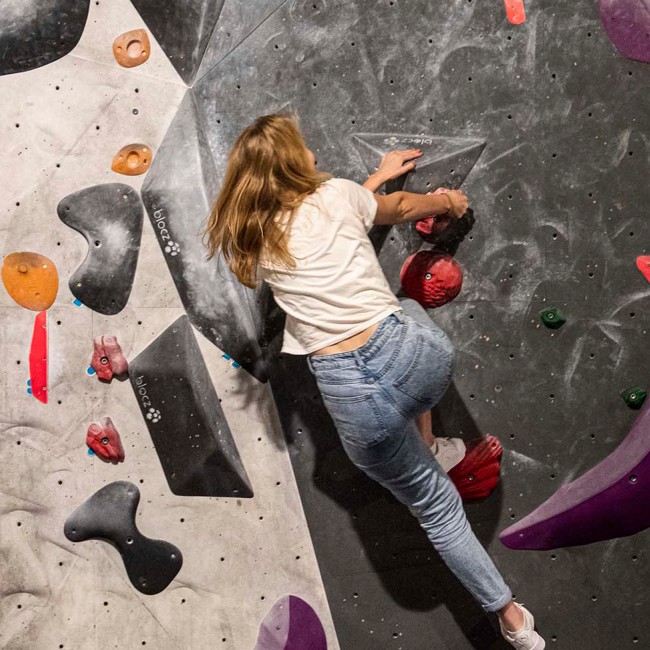 A student climbing on a bouldering wall