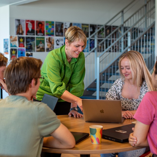 Docent geeft les aan kleine groep studenten