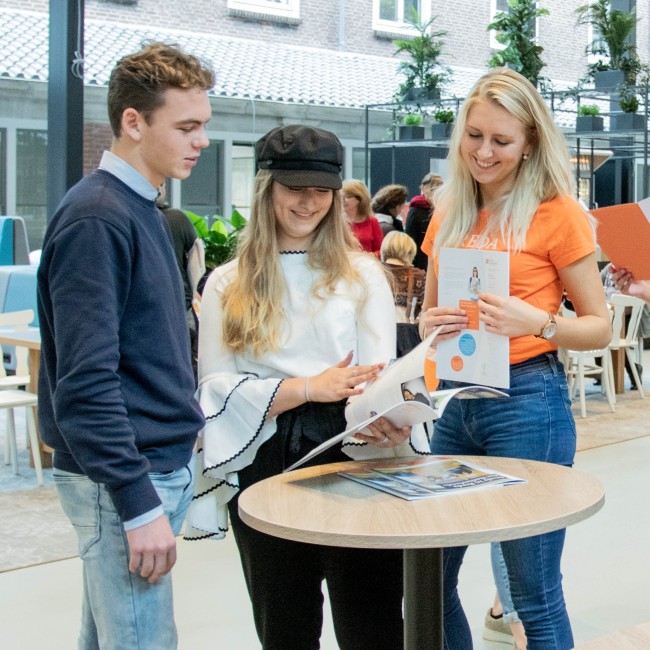 Studiekiezers en een student staan samen op de open dag