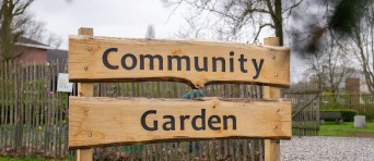 Bord waarop community garden staat